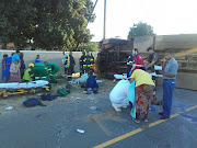 Paramedics attend to injured workers after a County Fair staff bus that overturned in Cape Town on Thursday.