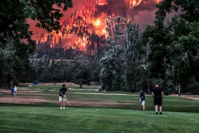 The Eagle Creek wildfire burns as golfers play at the Beacon Rock Golf Course in North Bonneville, Washington, 4 September 2017. Photo: Kristi McCluer / REUTERS