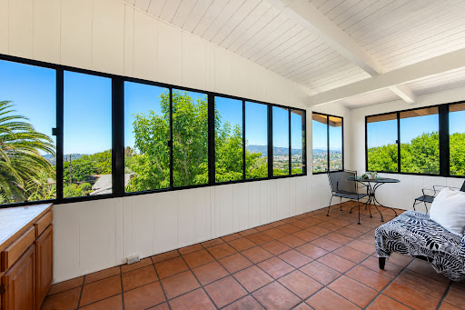Living room with large windows and green view - Buy this luxury house in Los Angeles, 3 bedrooms