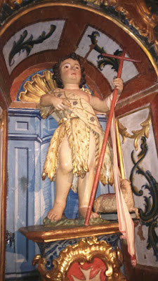 La imagen de San Juan Bautista representado como niño, portando un estandarte en forma de cruz y acompañado por un cordero que reposa sobre un libro
