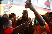 Domestic workers and members of Cosatu take selfies with ANC president Cyril Ramaphosa, after he delivered the keynote address at the Mall of Thembisa in Ekurhuleni on October 28 2021 at an event to recognise the role of domestic workers. 