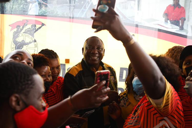 Domestic workers and members of Cosatu take selfies with ANC president Cyril Ramaphosa, after he delivered the keynote address at the Mall of Thembisa in Ekurhuleni on October 28 2021 at an event to recognise the role of domestic workers.