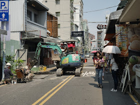 woman carrying a baby past construction work by the Taiwan Water Corporation at Zhengxing Street in Tainan