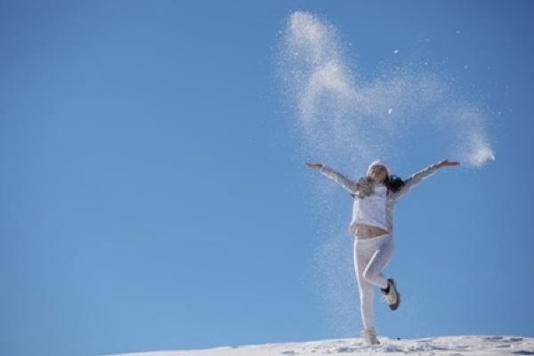 Th young happy girl plays with snow