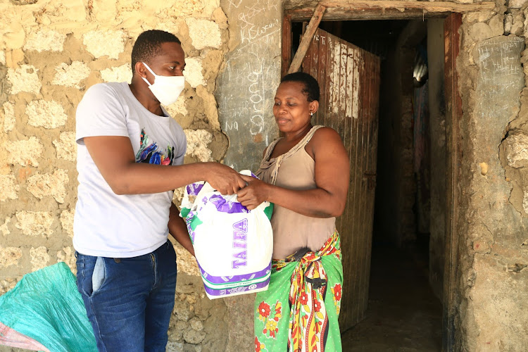 Sidi Chai receives her relief food from Sulaimna Ngala on Friday.