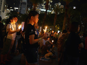 young woman holding a candle at the vigil in Victoria Park, Hong Kong, commemorating the anniversary of the Tiananmen Square crackdown