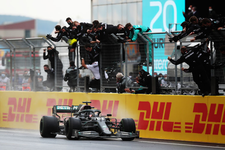 Mercedes team members celebrate on the pitwall as Lewis Hamilton of Great Britain driving the (44) Mercedes AMG Petronas F1 Team Mercedes W11 crosses the finish line to win during the F1 Grand Prix of Turkey at Intercity Istanbul Park on November 15, 2020 in Istanbul, Turkey.