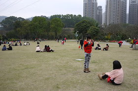 young woman taking a photo of another at Bailian Dong park in Zhuhai China