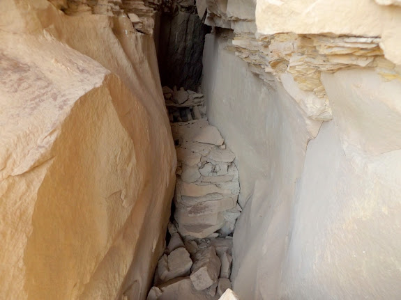 Granary hidden behind a rock slab