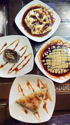 Clockwise desserts at DarSalam you see Baklava, a Date Roll and a dessert called Dark & Honey