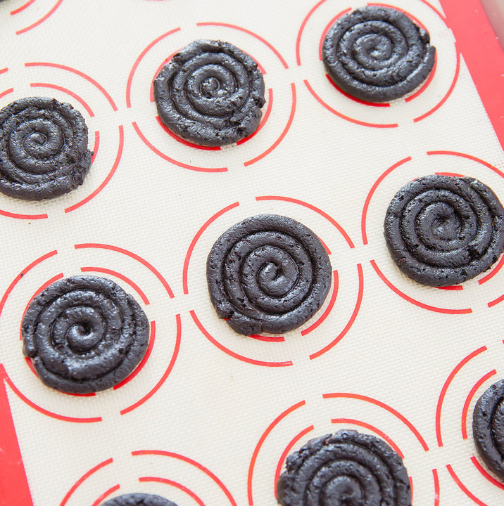 step by step photo showing how to pipe the oreo churro dough into a cookie shape