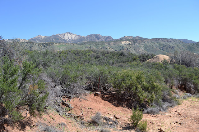 survey marker at the side of the former road with mountains