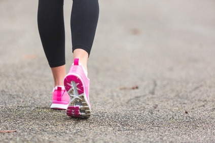 Female Runner Shoes closeup on the road, town setting. Shallow depth of Field, focus on rear shoe. 