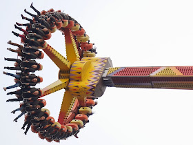 People briefly suspended high above the ground on an amusement park ride at Foreigners' Street in Chongqing.