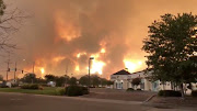 Smoke and flames are seen as a wildfire spreads through Redding, California, the US, July 26, 2018, in this still image taken from a video obtained from social media. 