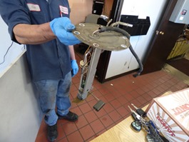 Repairman Carlos holding old fuel pump