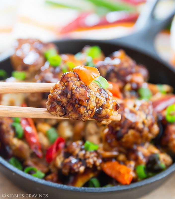 close-up of chopsticks holding a piece of Kung Pao Cauliflower