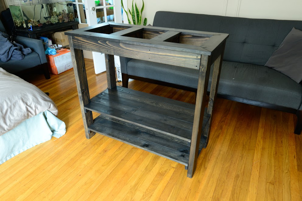 The finished aquarium stand with adjustable shelves. I designed and built it from scratch as my first foray into woodworking. Despite running out of stain, I am quite pleased with it!