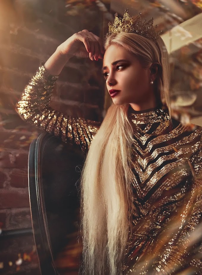 The beautiful blonde girl puts a wedding crown on her head