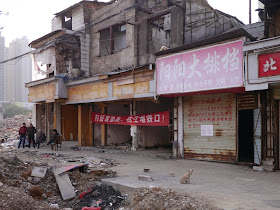 women standing and a dog sitting outside some remaining buildings at Beizheng Street in Changsha