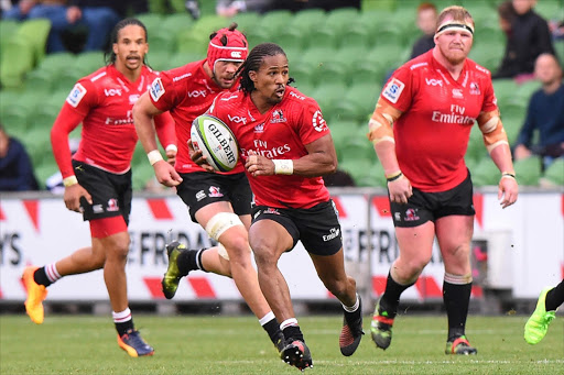 Lions' Sylvian Mahuza (C) runs with the ball during the Super Rugby match between the Melbourne Rebels and Golden Lions at AAMI Park in Melbourne on May 6, 2017.