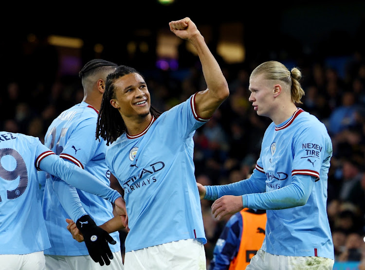 Manchester City's Nathan Ake celebrates scoring against Arsenal with teammates.