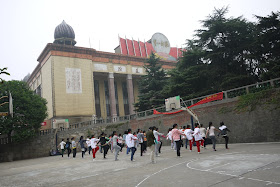 students in a fitness class at a basketball court in front of the library at Hunan First Normal University in Changsha, China