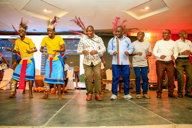 Kwale Deputy Governor Kombo Chirema and Uganda Consul General in Mombasa Ambassador Paul Mukumbya join Ndere Troupe Dancers during the Uganda Festival held at the Diani Reef Beach Hotel on Wednesday.