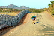 The R37m fence on the border of SA and Zimbabwe is cut daily as Zimbabweans cross into SA. ‘We make big holes so we can get suitcases with cigarettes through, and small ones so we can get people and groceries through,’ said one smuggler. File photo.