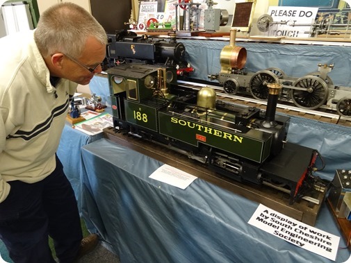 Publicity photo - a visitor views a display of  locomotives and engines