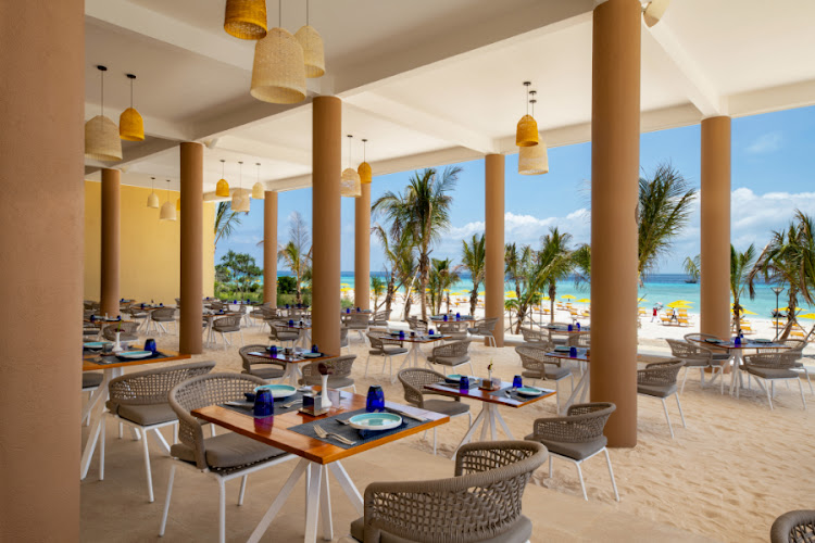 The Beach Club Grill restaurant, where diners sit shielded from the sun with their toes in the sand.