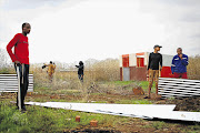 MEET THE NEW NEIGHBOURS: Community members in Nellmapius, east of Pretoria, erect shacks in 'Malemaville'. Economic Freedom Fighters officials yesterday morning allocated portions of land to people in defiance of a court order blocking the illegal invasion of council-owned land