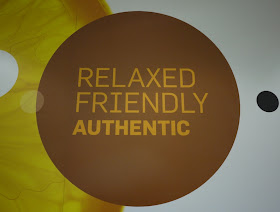 sign inside KFC saying RELAXED, FRIENDLY, AUTHENTIC