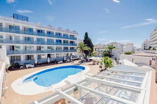 una gran piscina rodeada de edificios blancos y palmeras