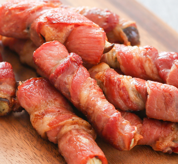 a pile of bacon-wrapped eggplant fries on a cutting board