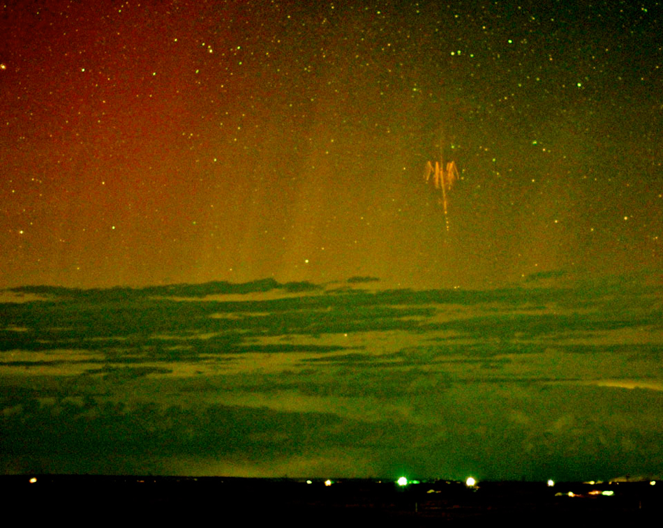 Una imagen única: espectro rojo fotografiado junto a una aurora boreal