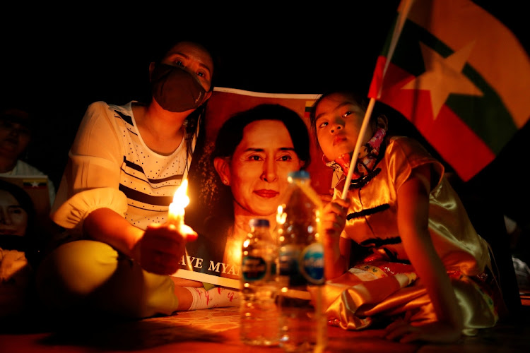 Migrants protesting against the military junta in Myanmar hold a picture of leader Aung San Suu Kyi, during a candlelight vigil at a Buddhist temple in Bangkok, Thailand on March 28 2021.