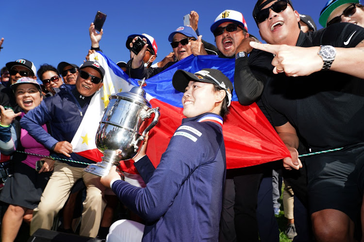 Yuka Saso hoists the US Open trophy with a group of spectators after winning in a sudden death playoff over Nasa Hataoka after the final round of the US Women's Open golf tournament at The Olympic Club