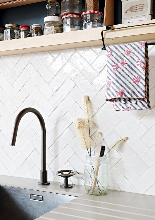 Handmade tiles laid in a herringbone pattern form a stylish backdrop to the birch ply kitchen.