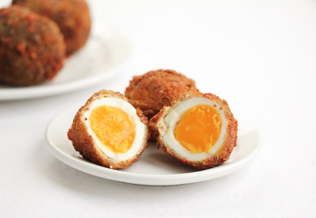 photo of a fried bacon egg sliced in half on a plate