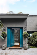 Exterior painted in Dulux Rattlesnake; front door painted in Dulux Submarine.
Potted bay trees (Laurus nobilis) stand sentinel by the door.

