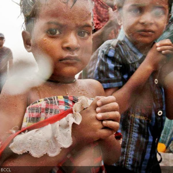 Evacuated young Indian villagers are brought to a relief camp as it rains near Berhampur.