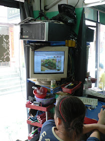 lady playing a game on a computer that is sitting on top of its monitor
