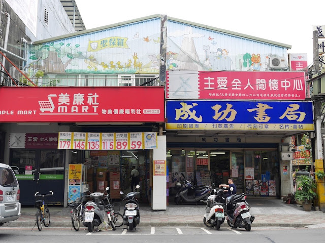 front of a building on Zhongzheng Road, Luzhou District, New Taipei City, with a large flag of the U.S. painted on its side 