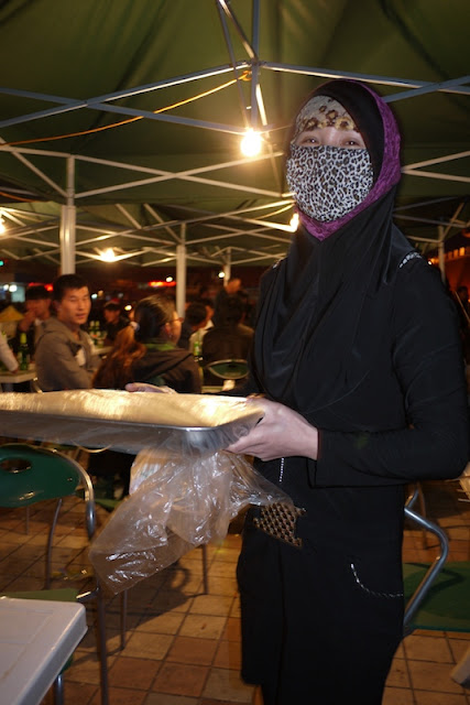 Muslim woman holding a tray of vegetable dishes in Yinchuan, Ningxia