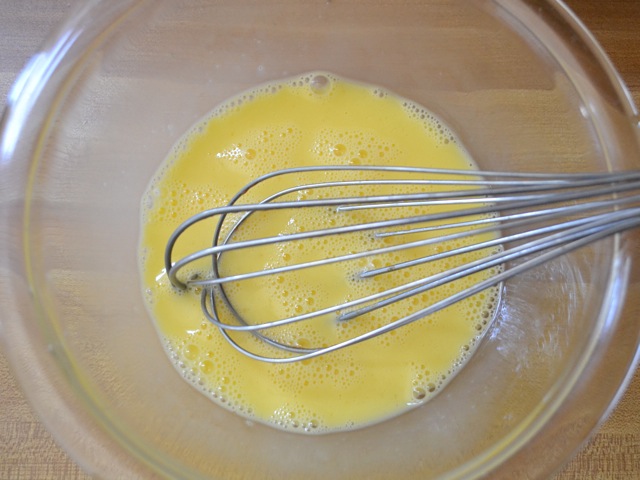 eggs and milk being whisked together 