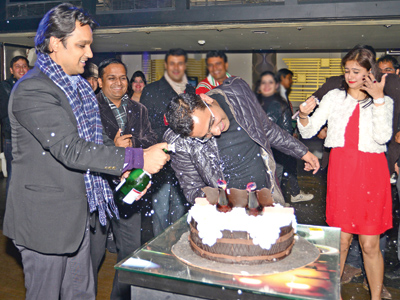 Munish sprays champagne on the birthday boy as Abhisek Kedia looks on during a bash, held in Lucknow.  