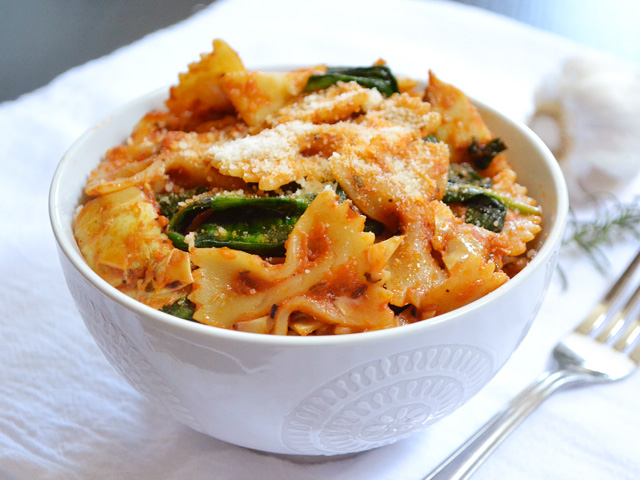 A bowl of Zesty Tomato & Artichoke Pasta with a fork on the side 