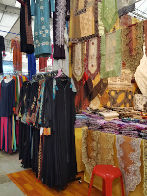 Table runners jostle with abayas. Traditional Arabic-style clothing was very much in evidence.