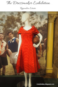 Kate Winslet's costume in The Dressmaker - red structured dress, mannequin holding a football. 